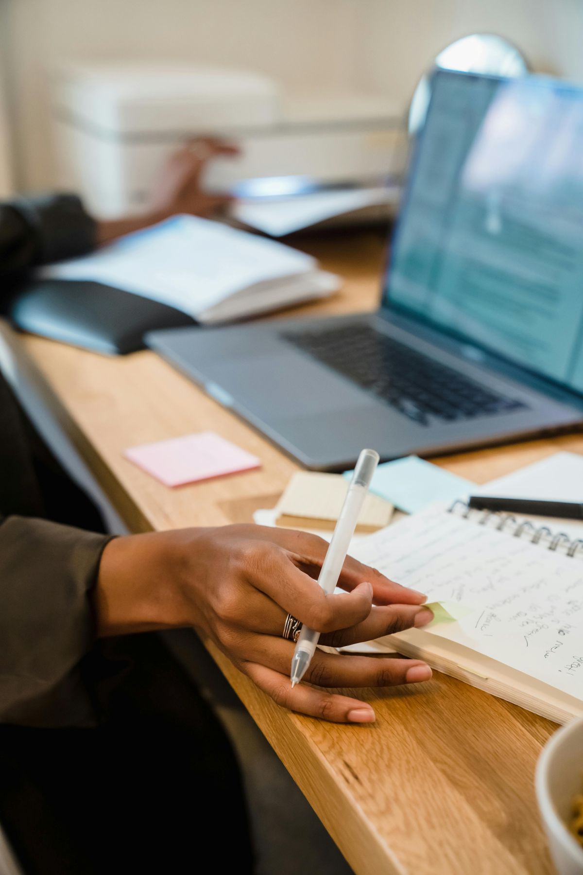 Agent commercial prenant des notes sur un carnet à côté d'un ordinateur, illustrant le rôle des agents commerciaux partenaires des 2 Rives